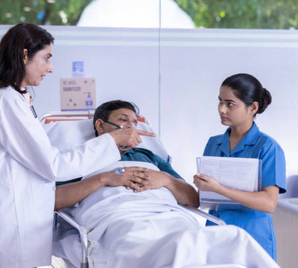 Female doctor scolding nurse with report while patient is lying on stretcher bed at hospital